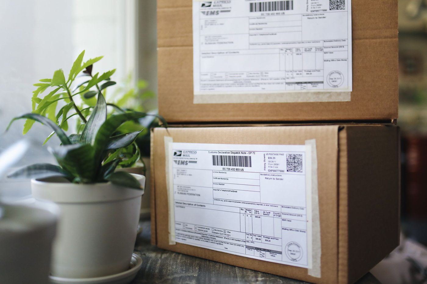 Stacked shipping boxes on warehouse pallet racking, representing packaging distribution